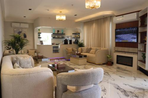 a large living room with couches and a fireplace at جوهرة دومة الجندل للشقق المخدومة Jawharat Dumat Serviced Apartments in Dawmat al Jandal