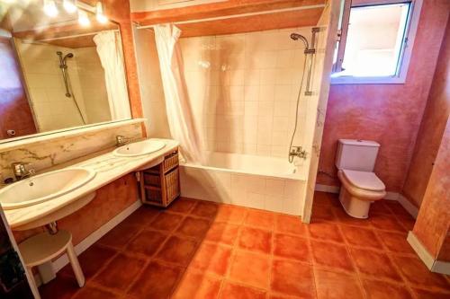 ein Badezimmer mit einem Waschbecken, einer Badewanne und einem WC in der Unterkunft Hastinapura, acceso directo al mar in Es Castell