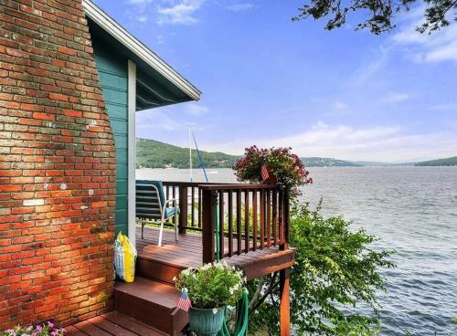 a house with a deck with a view of the water at Winnipesaukee Lakefront w/ Dock in Laconia
