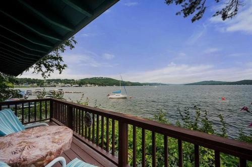 a balcony with a view of a boat in the water at Winnipesaukee Lakefront w/ Dock in Laconia
