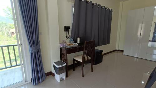 a room with a desk with a phone and a window at Khao Sok Family Room House in Khao Sok National Park