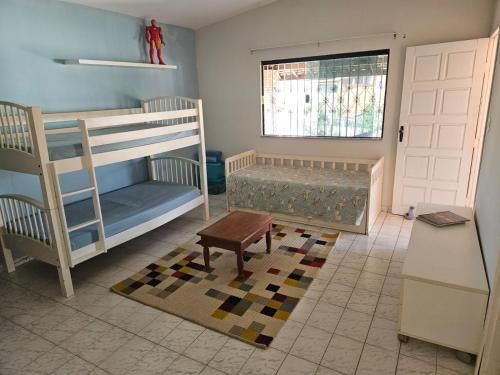 a room with two bunk beds and a window at Casa para temporada in Vera Cruz de Itaparica