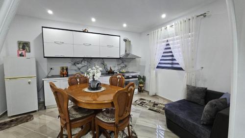 een keuken en eetkamer met een tafel en een koelkast bij Guesthouse Albi in Berat