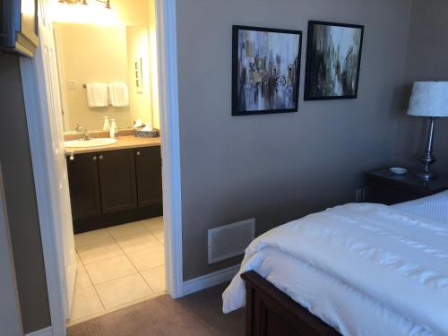 - une chambre avec un lit et une salle de bains pourvue d'un lavabo dans l'établissement Willow Pond Satellite B&B, à Port Perry