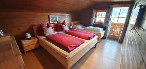 a bedroom with two beds in a log cabin at Talblickhütte in Rauris