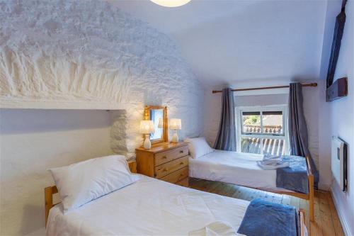 1 dormitorio con 2 camas y ventana en Crew's Apartment, en Dungarvan