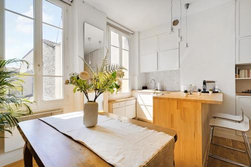 une cuisine avec une table avec un vase de fleurs dessus dans l'établissement Superbe T2 Bon Marchés Rive Gauche, à Paris