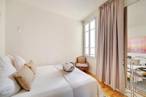 une chambre blanche avec un lit et une fenêtre dans l'établissement Superbe T2 Bon Marchés Rive Gauche, à Paris