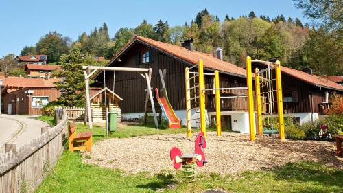 a playground in front of a building with slides at Ferienwohnung Enzian 4 im Feriendorf Sonnenhang im Allgäu in Missen-Wilhams