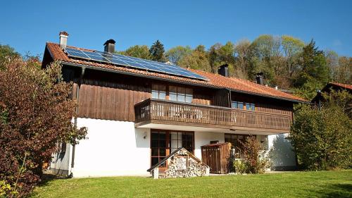 a house with a roof with solar panels on it at Ferienwohnung Enzian 4 im Feriendorf Sonnenhang im Allgäu in Missen-Wilhams