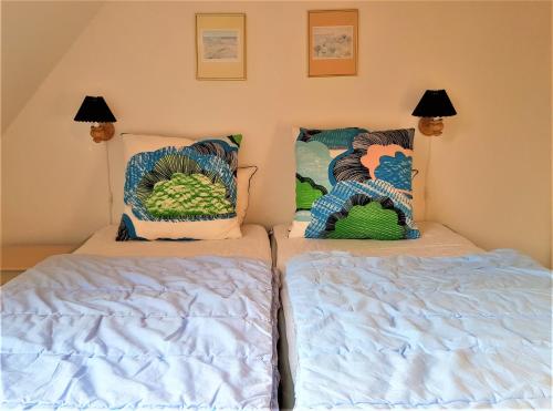 two beds sitting next to each other in a bedroom at Pyttegården Apartments in Gudhjem