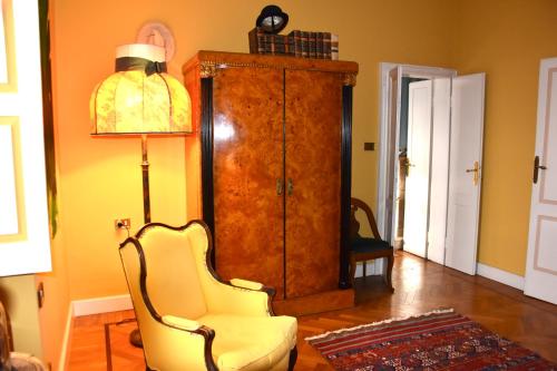 a living room with a chair and a cabinet at Relais Villino Rubini in Brunate