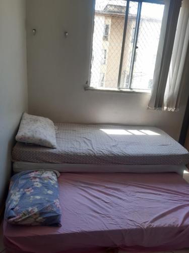 2 łóżka w małym pokoju z oknem w obiekcie zona sul de Ilheus ,próximo a praia dos milionário w mieście Ilhéus