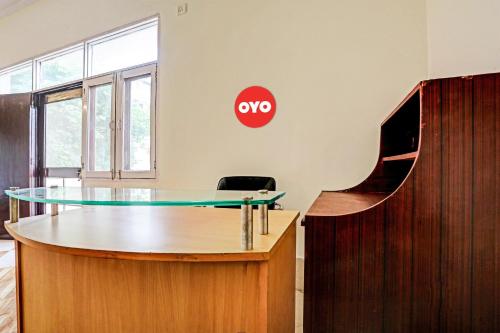 an office with a glass table and a sign on the wall at OYO Flagship Hotel Jagdambey Residency in Noida