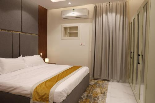 a bedroom with a large bed and a window at جوهرة دومة الجندل للشقق المخدومة Jawharat Dumat Serviced Apartments in Dawmat al Jandal