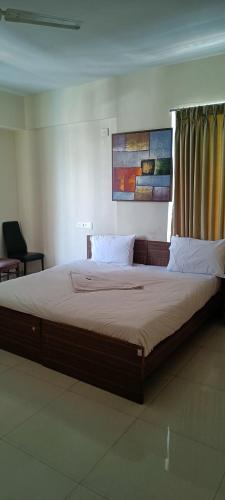 1 cama grande en un dormitorio con ventana en Hotel Grandview en Chinchiwad