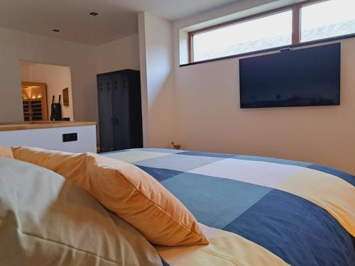 1 dormitorio con cama y ventana grande en AMIKALEMENT VÔTRE - Gîte 2 personnes en La Roche-en-Ardenne