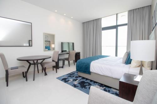 pokój hotelowy z łóżkiem, stołem i krzesłami w obiekcie Luxury living near Dubai Expo - Dubai South - Ezytrac Vacation Homes w Dubaju