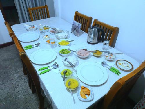 a table with plates and bowls of food on it at Green Villa in Nuwara Eliya