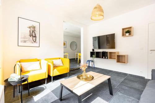 un soggiorno con divano giallo e tavolo di Le Gîtel a Spa