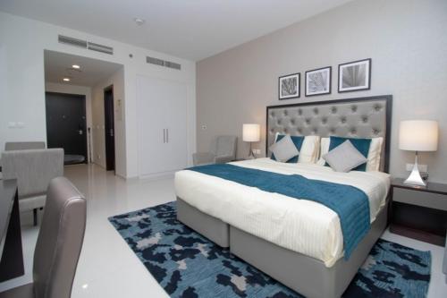 a bedroom with a large bed with a blue blanket at Affordable Living near Dubai Al Makhtom Airport - Ezytrac Vacation Homes in Dubai