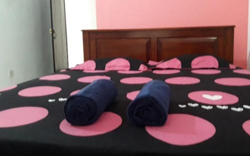 un lit avec des points de polka roses et roses dans l'établissement Rajagaha Hotel, à Radawana