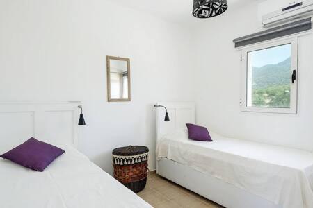 a white room with two beds and a window at Joya Cyprus Mermaid Penthouse Apartment in Saint Amvrosios