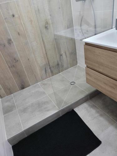 une salle de bain avec une douche avec un lavabo et une baignoire dans l'établissement Charmant T3 avec terrasse, à Carcassonne