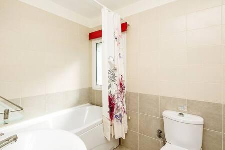a bathroom with a tub and a toilet and a sink at Joya Cyprus Maroon Garden Apartment in Saint Amvrosios