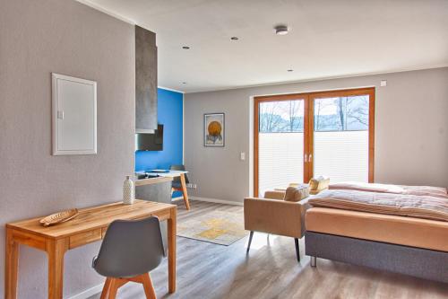 una camera con letto, tavolo e scrivania di City Apparte Exklusiv - direkt am Antonius-Hospital - Auto-E-Ladestation a Gronau
