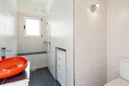 a bathroom with a red sink and a shower at Joya Cyprus Mandarin Penthouse Lux Apartment in Ayios Nikolaos