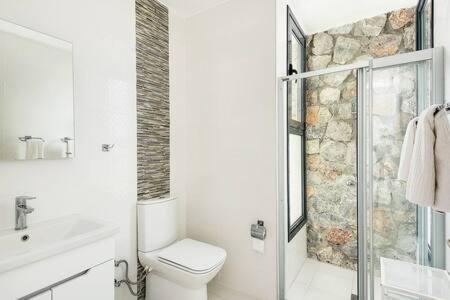 a white bathroom with a toilet and a shower at Joya Cypern Seaside Luxurious Villa and Private Pool in Akanthou