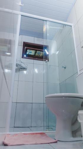 a bathroom with a glass shower and a toilet at Casa Mico Leão Dourado in Bombinhas