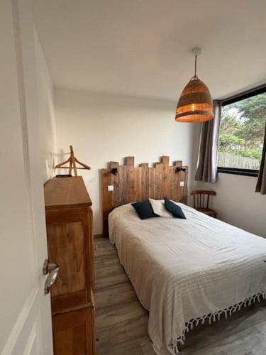 une chambre avec un grand lit avec une tête de lit en bois dans l'établissement La Perle des Dunes- Front de mer- Accès direct plage, à Montmartin-sur-Mer