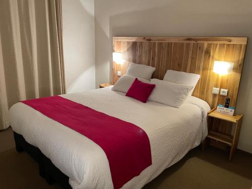 a bedroom with a large bed with a red blanket at Logis Hôtel de France & Restaurant Pamiers in Pamiers