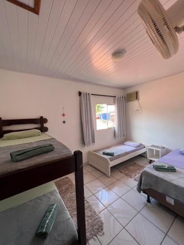 um quarto com duas camas e uma janela em Aluê Hostel em Arraial d'Ajuda