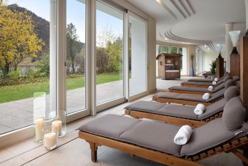 fila de camas en una habitación con ventanas grandes en Arabella Alpenhotel am Spitzingsee, a Tribute Portfolio Hotel en Spitzingsee