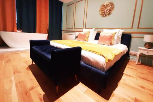 ein Schlafzimmer mit einem Bett, einer Badewanne und einem Stuhl in der Unterkunft ROYAL SUITE PARIS REPUBLIQUE in Paris