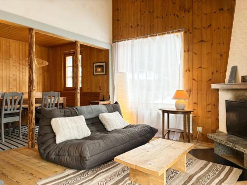 a living room with a leather couch and a table at Chalet Marolly - Evolène in Evolène