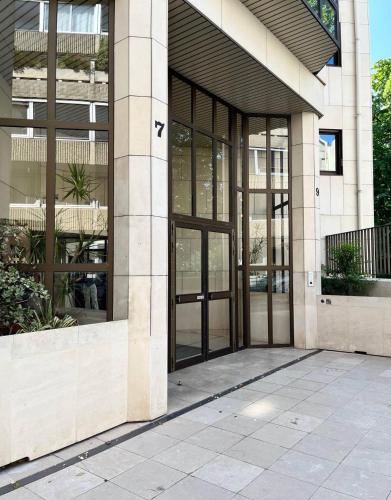 un bâtiment avec des portes en verre sur son côté dans l'établissement Parisian cocoon- Luxembourg garden- Independant, à Paris