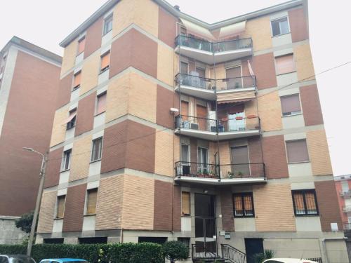 un edificio alto de ladrillo con balcones en una calle en Casa Manolo Corsico Navigli Suite Apartment Milan en Corsico
