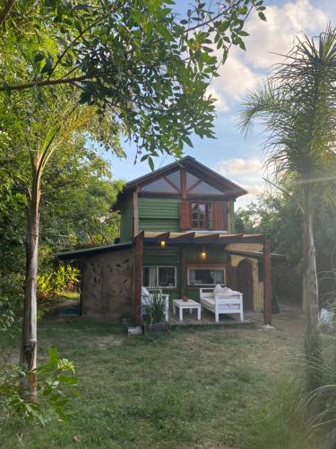 uma casa com um banco branco em frente em Cabaña La Sencillita em Neptunia