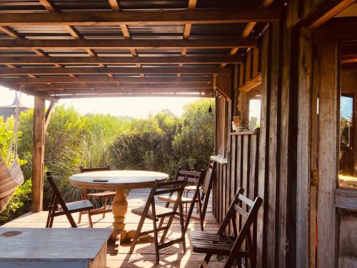 un patio avec une table et des chaises sur un porche dans l'établissement Casa de barro, à Punta Colorada