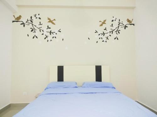 a bedroom with a bed with birds on the wall at “彬彬”星空瞭望台 ( The Venus 33rd floor @ Sri Manjung ) in Kampong Lumut Kiri