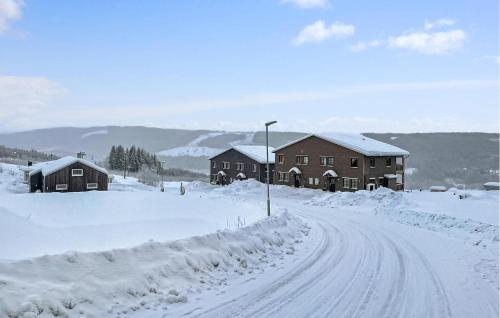 Una carretera cubierta de nieve al lado de dos edificios en Gorgeous Apartment In Sysslebäck, en Sysslebäck