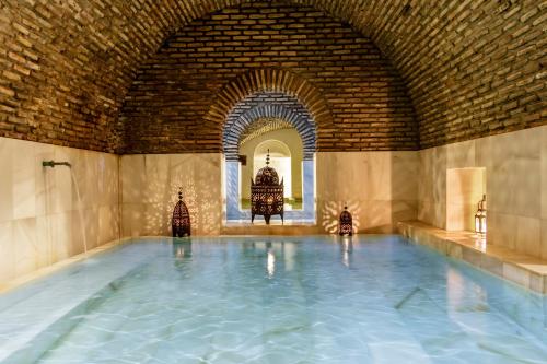 a large indoor swimming pool with a brick wall at Entre Dos Aguas Hotel Boutique in Toledo