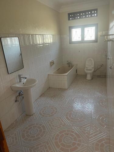 a bathroom with a tub and a toilet and a sink at 7 Days Hotel in Entebbe