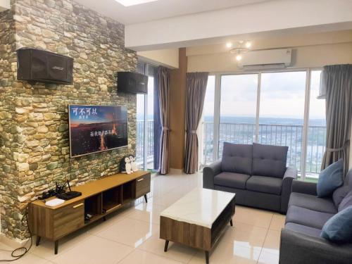 a living room with a tv and a stone wall at “彬彬”星空瞭望台 ( The Venus 33rd floor @ Sri Manjung ) in Kampong Lumut Kiri