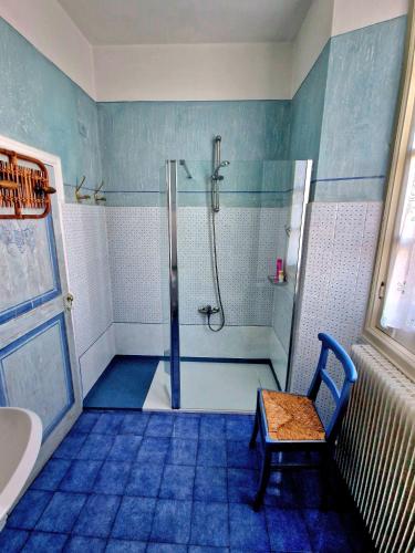 a bathroom with a shower with a bench and a chair at La Corte B&B in Ovada
