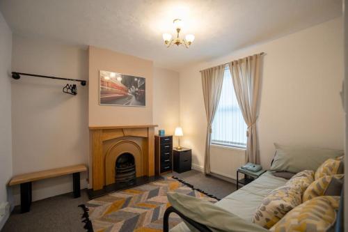 a living room with a couch and a fireplace at Birchmore House, by RentMyHouse 